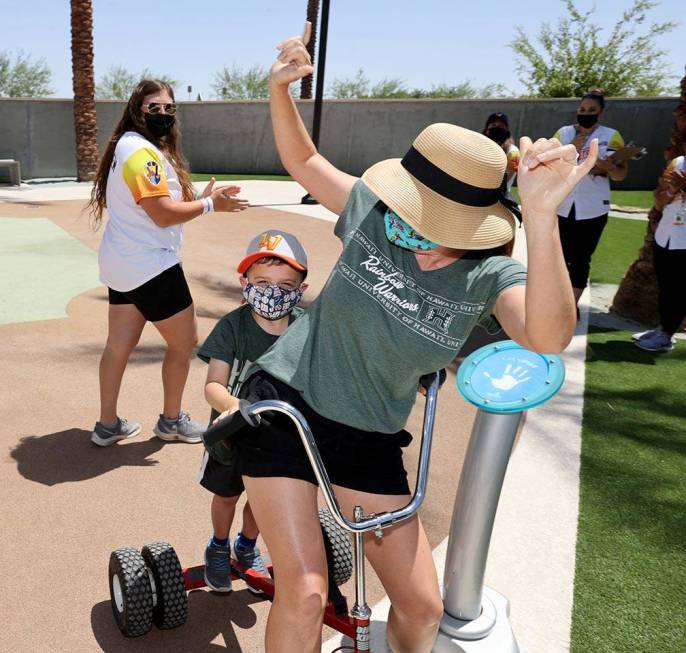 Rena Van Slyke and her son Dodge, 4, celebrate winning the tricycle race between innings as Avi ...