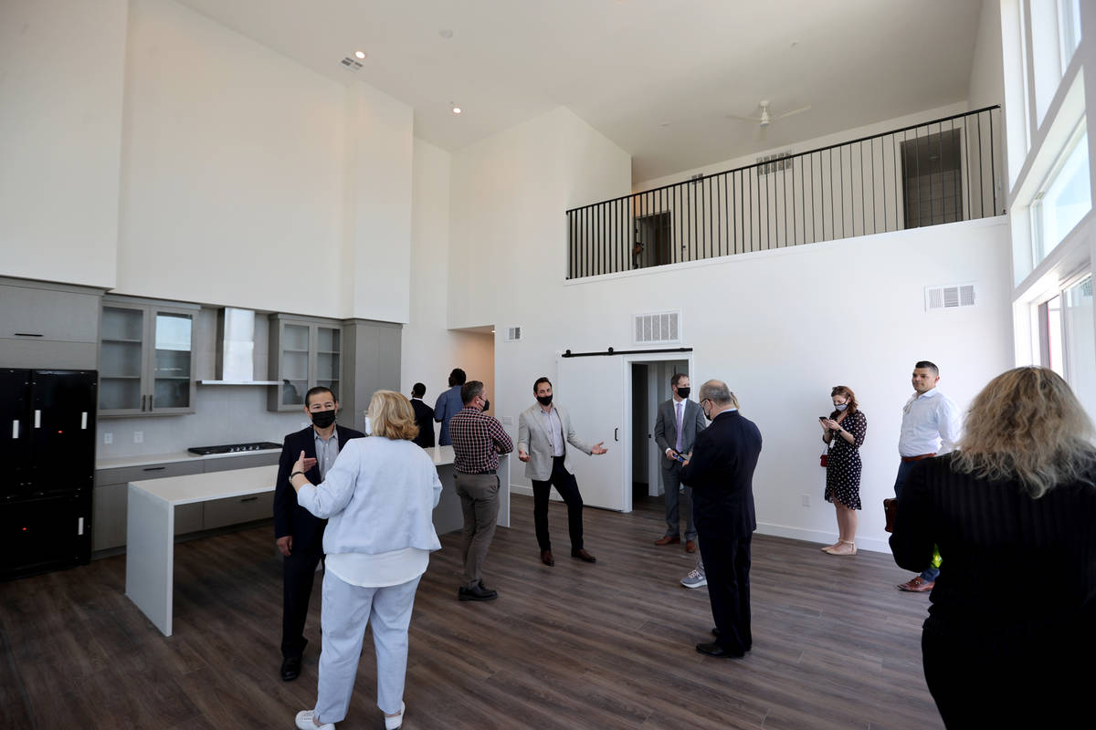 Patrick Brennan, development manager for Aspen Heights Partners, center, gives a tour of a pent ...