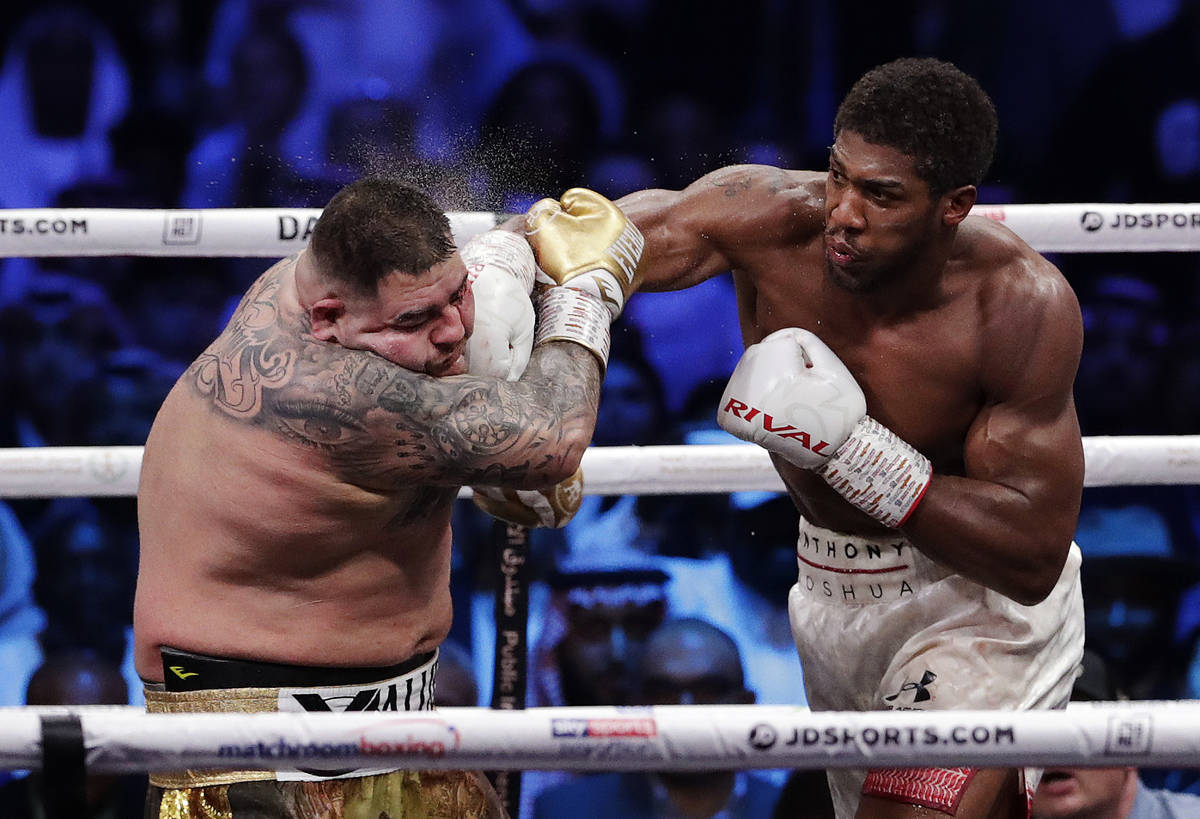 Defending champion Andy Ruiz Jr., left, takes a right cross to the face during his fight agains ...
