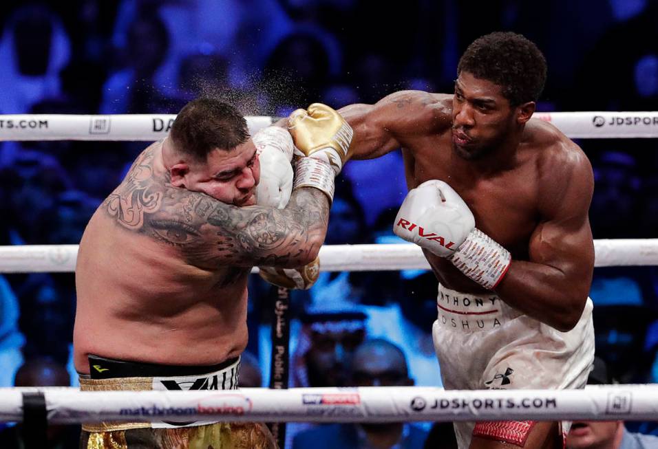 Defending champion Andy Ruiz Jr., left, takes a right cross to the face during his fight agains ...