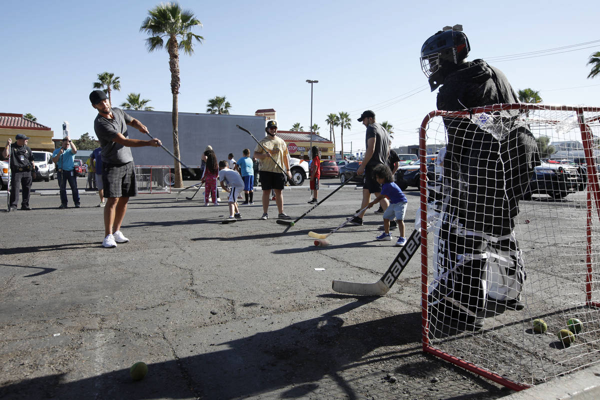 Former Golden Knights player Deryk Engelland, left, plays street hockey with children from a Me ...
