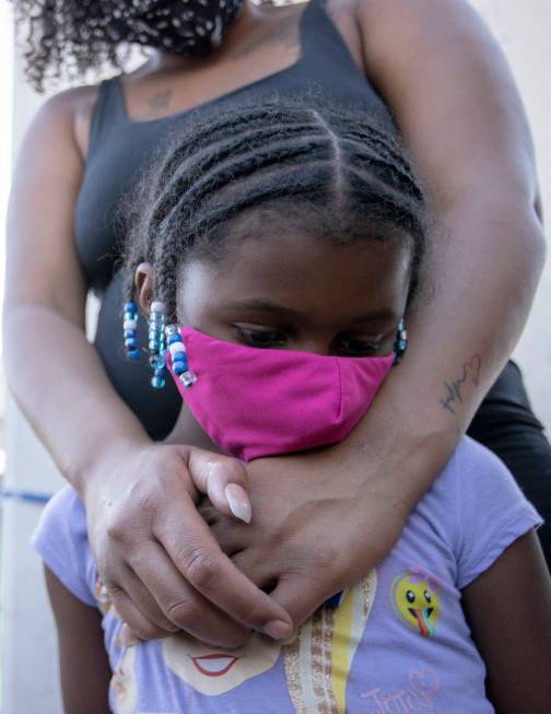 Marissa Neal embraces her daughter Shyla Hill, 6, during a vigil for 2-year-old Amari Nicholson ...
