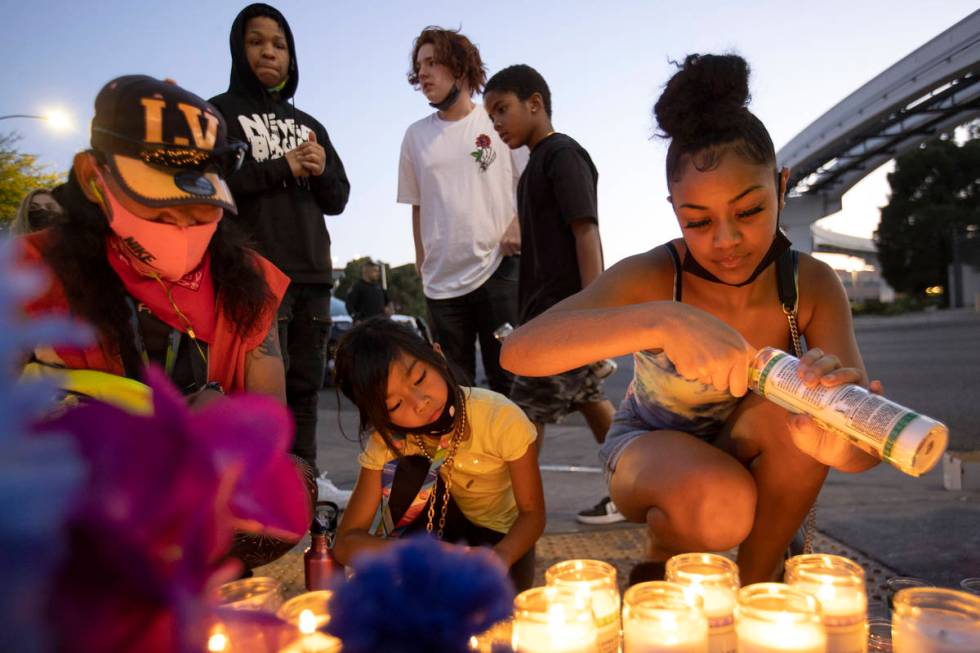 Ariyanah Nobriga, right, lights candles during a vigil for 2-year-old Amari Nicholson outside t ...