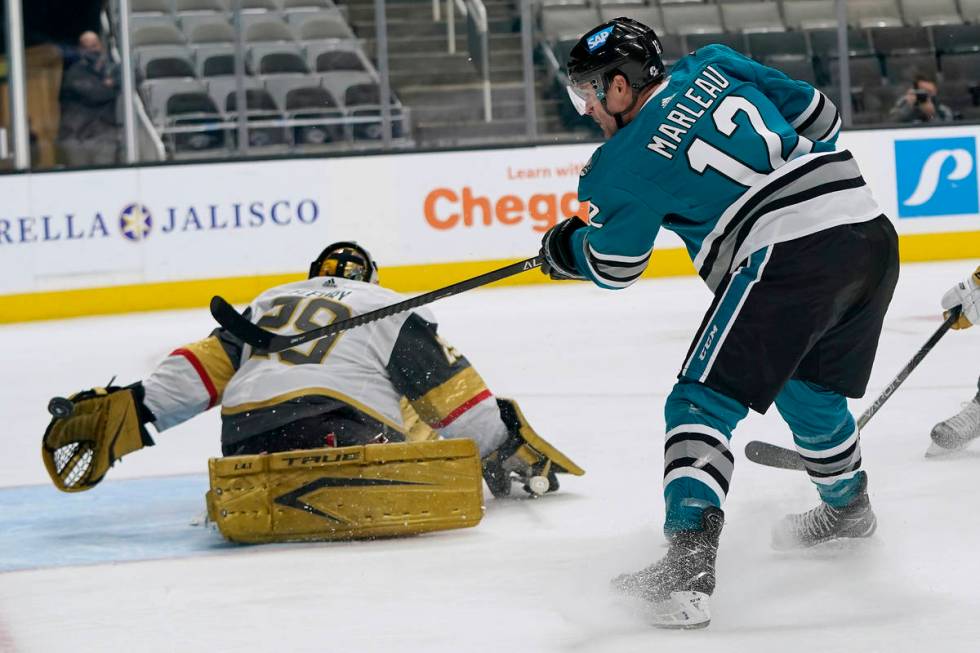 Vegas Golden Knights goaltender Marc-Andre Fleury, left, defends against a shot by San Jose Sha ...