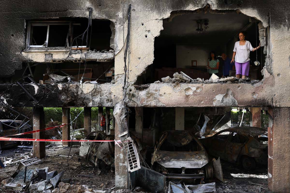 Members of Sror family inspect the damage of their apartment after it was hit by a rocket fired ...