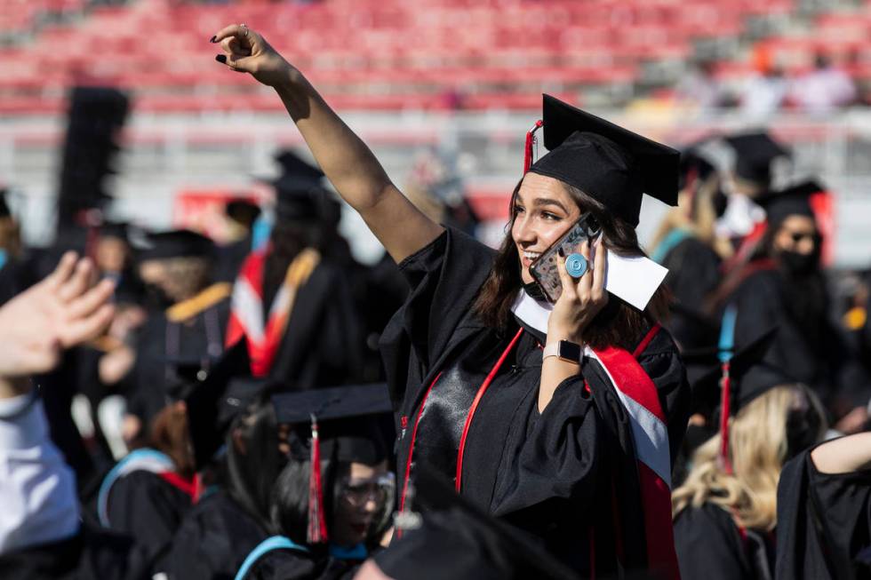 Michelle Adams waves as she tries to get her family's attention prior to getting her master's i ...