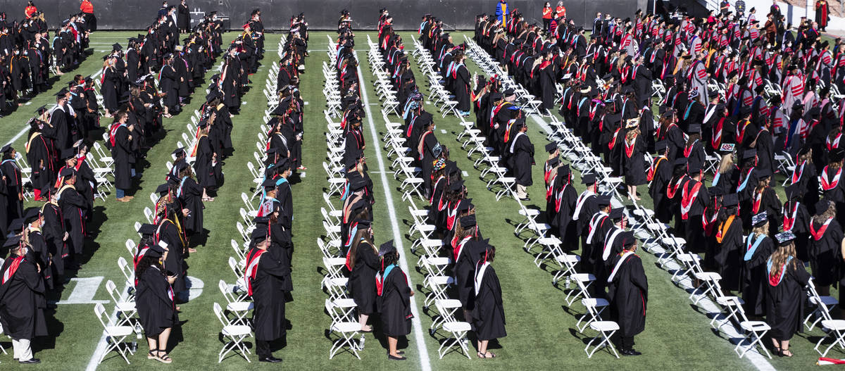 Graduates stand during the National Anthem as they attend the first of several UNLV graduation ...