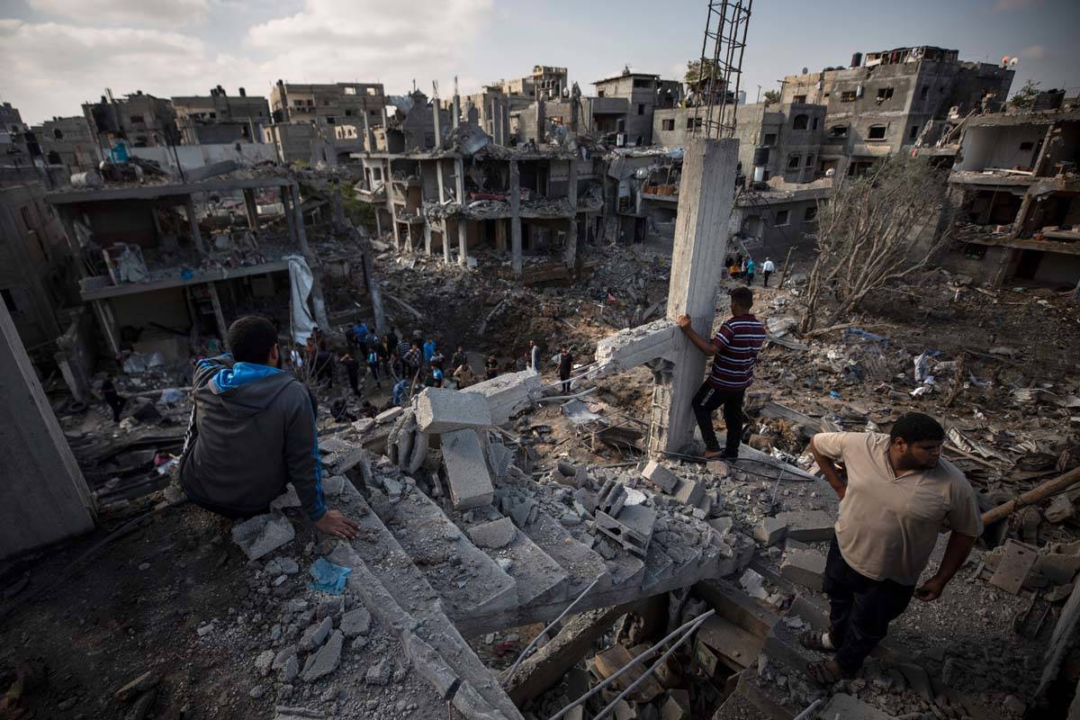 Palestinians inspect their destroyed houses following overnight Israeli airstrikes in town of B ...