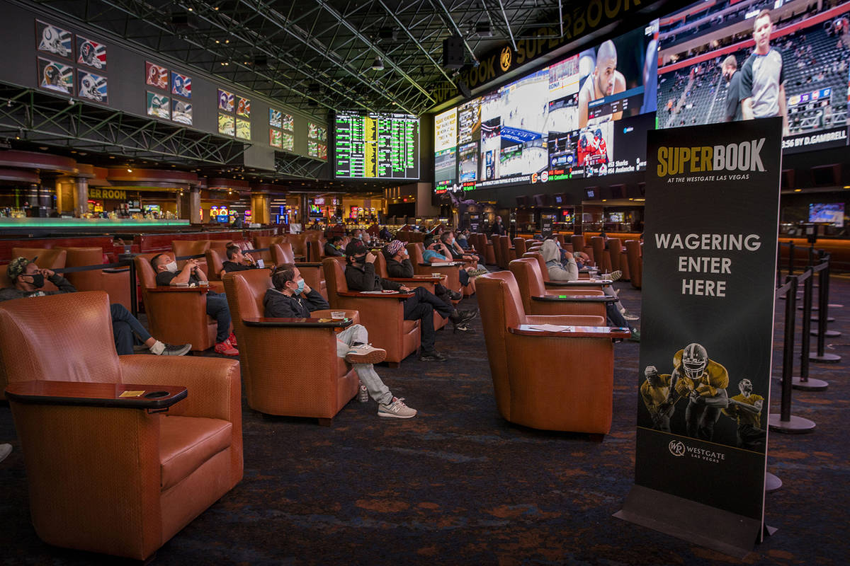 People watch events as the Westgate sportsbook posts hundreds of Super Bowl prop bets Jan. 28 i ...