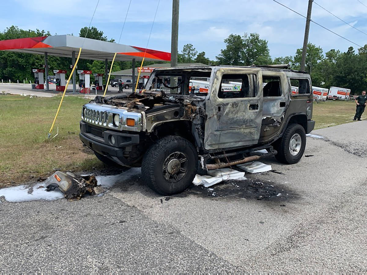 In this photo provided by Citrus County Fire Rescue an officer stands near a Hummer which was d ...