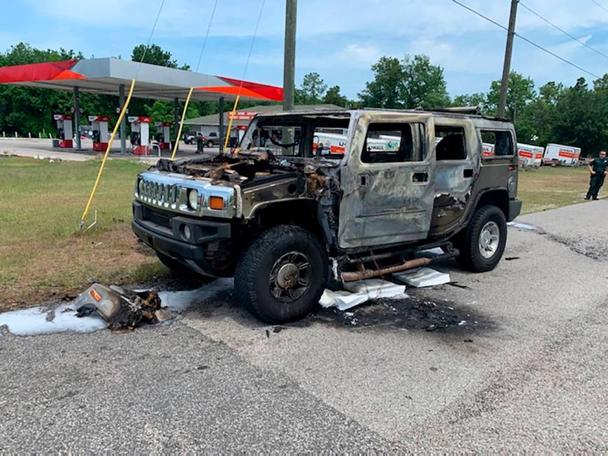 In this photo provided by Citrus County Fire Rescue an officer stands near a Hummer which was d ...