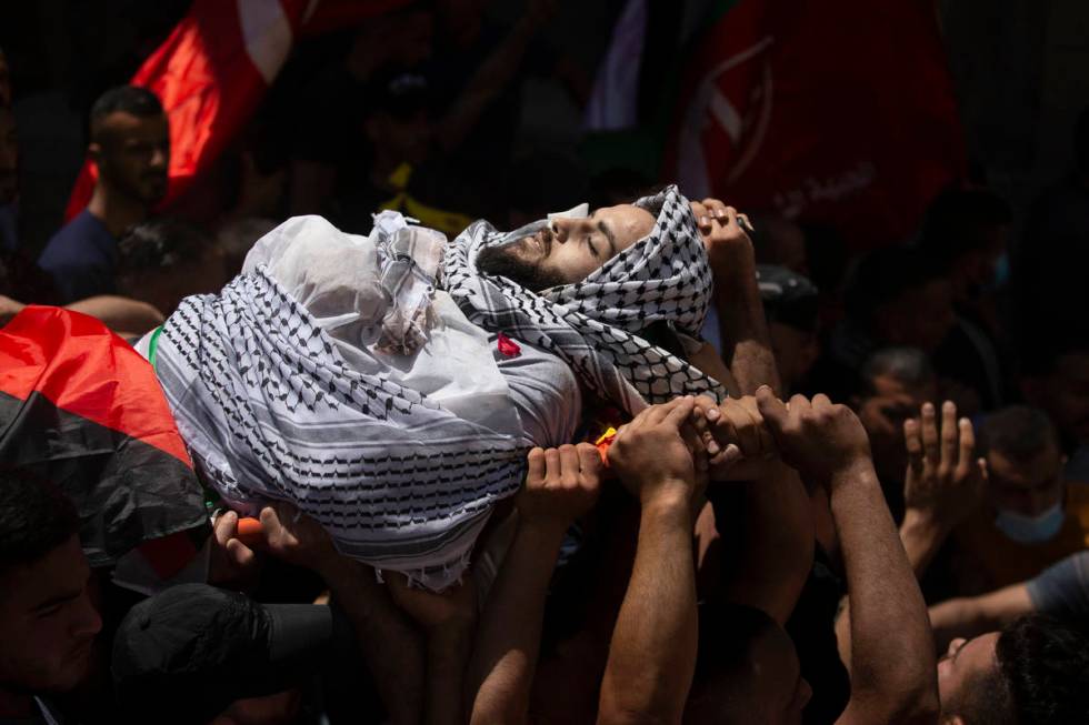 Palestinian mourners carry the body of Malek Hamdan who was killed in clashes with Israeli forc ...