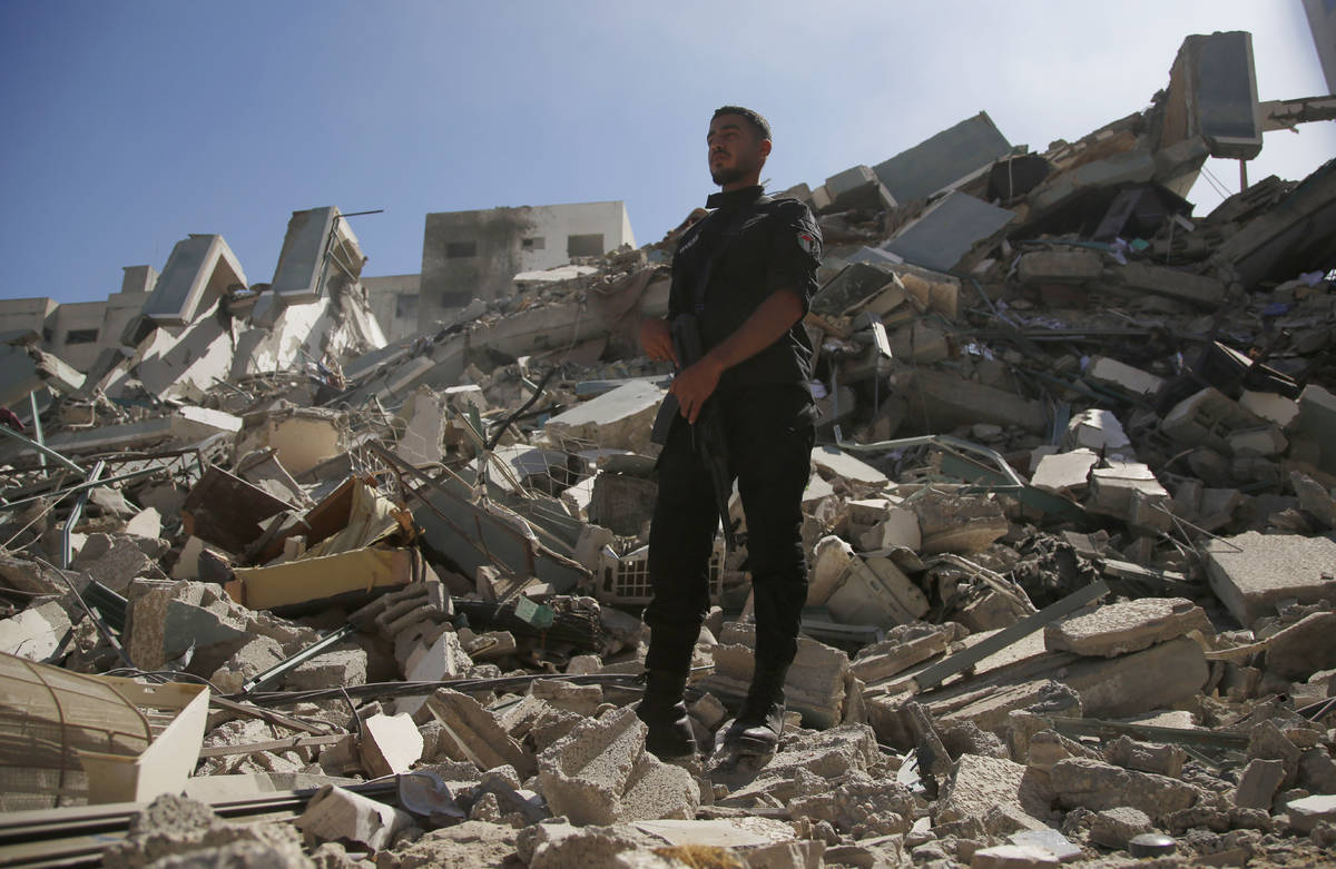 A man stands on rubble from a building housing AP office and other media in Gaza City that was ...