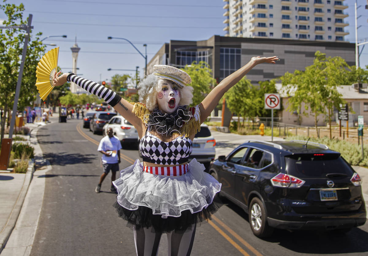 Stilt walker Jackie Daneri waves at passing cars during the Las Vegas Days Parade on Saturday, ...