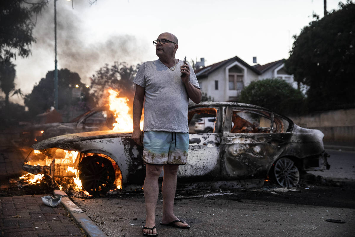 Jacob Simona stands by his burning car during clashes with Israeli Arabs and police in the Isra ...