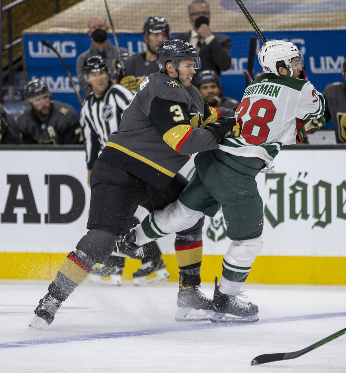 Golden Knights defenseman Brayden McNabb (3) checks Minnesota Wild right wing Ryan Hartman (38) ...