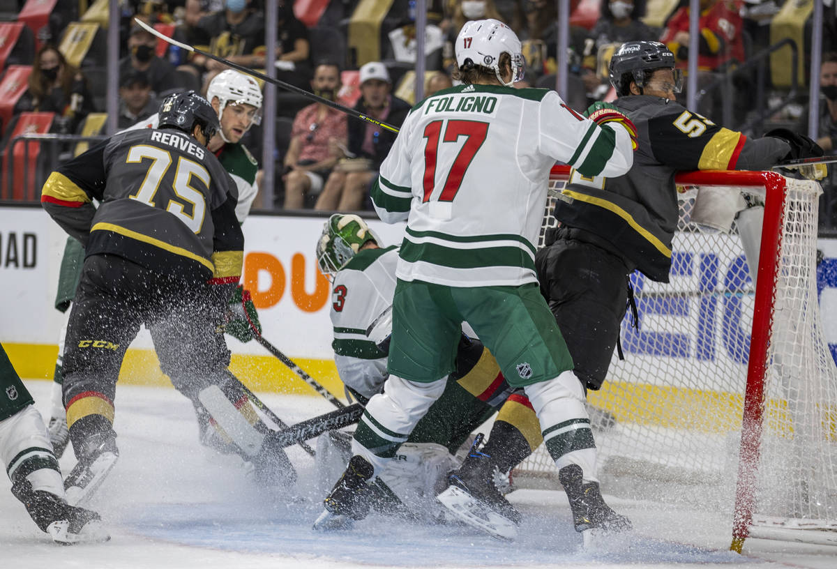 Minnesota Wild left wing Marcus Foligno (17) drives Golden Knights right wing Keegan Kolesar (5 ...