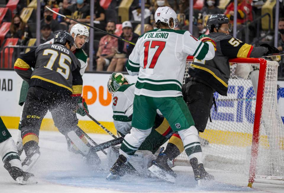 Minnesota Wild left wing Marcus Foligno (17) drives Golden Knights right wing Keegan Kolesar (5 ...