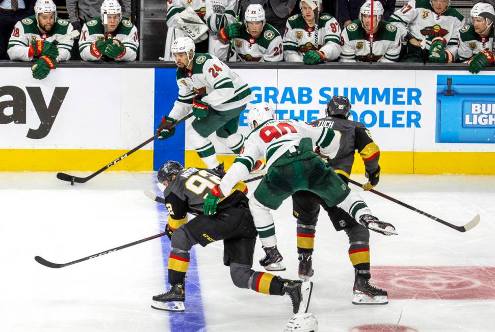 Minnesota Wild defenseman Matt Dumba (24) controls the puck as teammate center Marcus Johansson ...