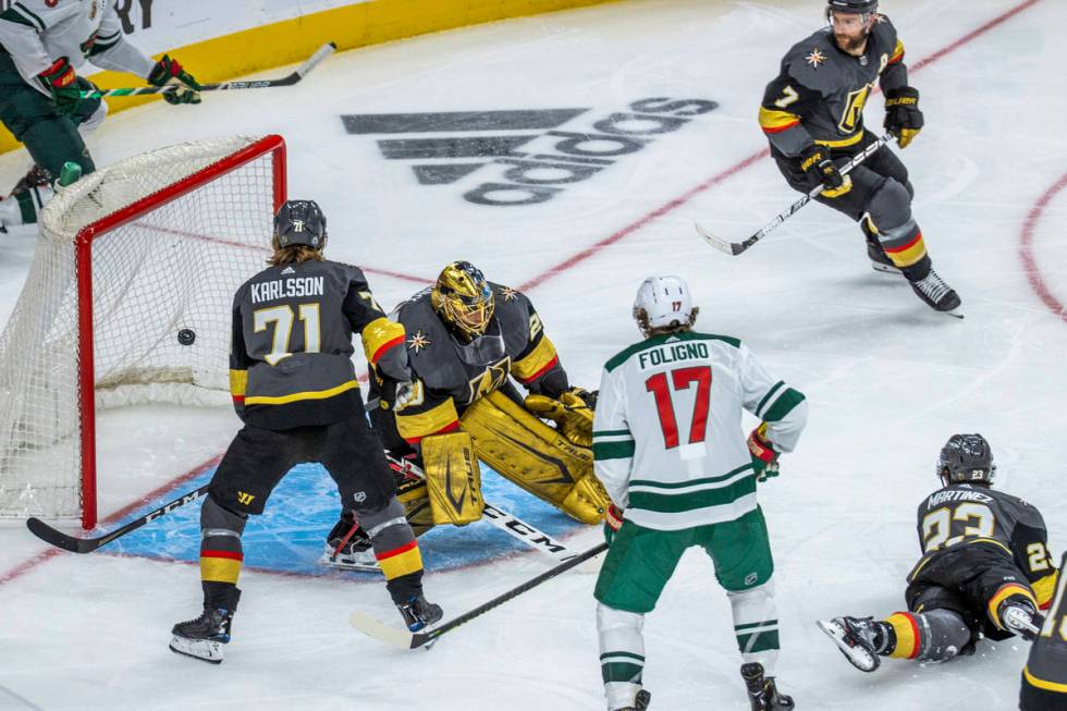 The puck gets past Golden Knights goaltender Marc-Andre Fleury (29) as Minnesota Wild center Jo ...