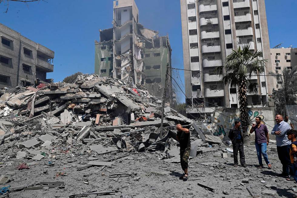 People inspect the rubble of a destroyed residential building that was hit by an Israeli airstr ...