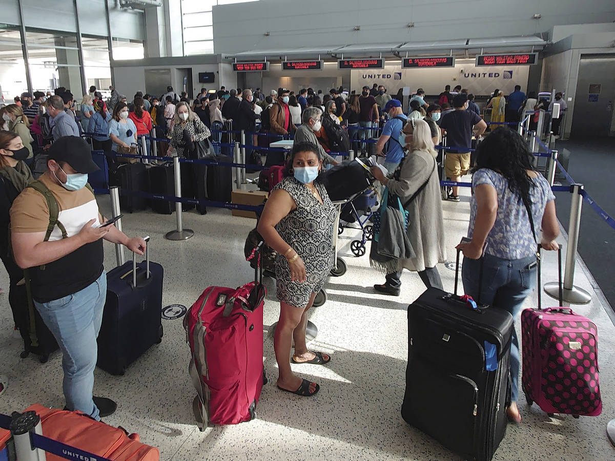 Airline passengers wait to check-in at George Bush Intercontinental Airport Sunday, May 16, 202 ...