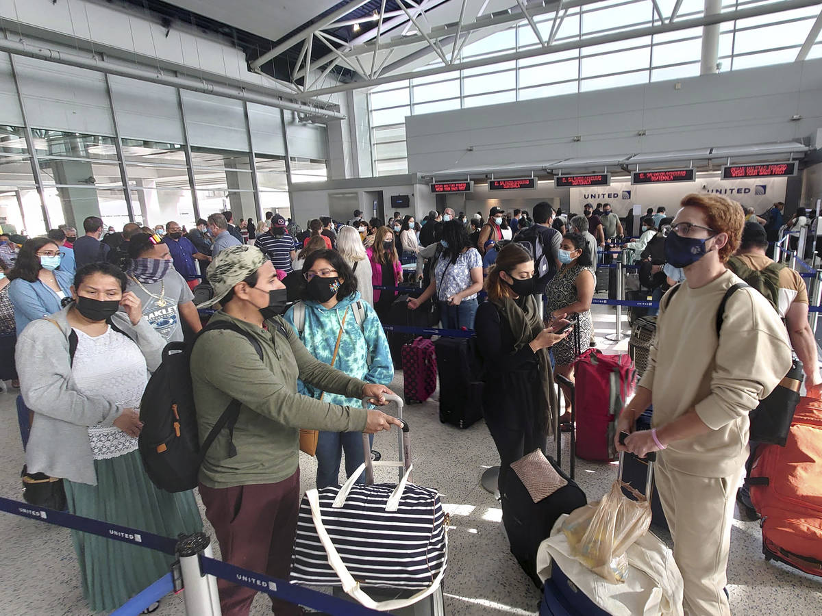 Airline passengers wait to check-in at George Bush Intercontinental Airport Sunday, May 16, 202 ...