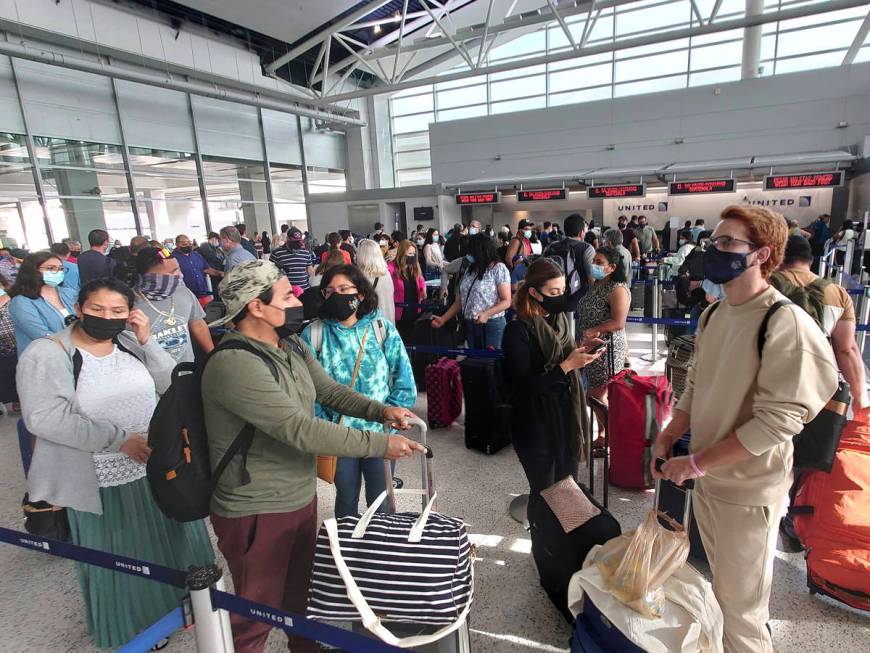 Airline passengers wait to check-in at George Bush Intercontinental Airport Sunday, May 16, 202 ...