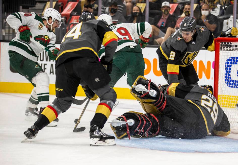 Golden Knights goaltender Marc-Andre Fleury (29) dives to the ice to assist teammate defenseman ...