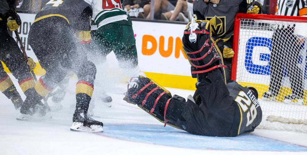 Golden Knights goaltender Marc-Andre Fleury (29) dives to the ice to assist teammate defenseman ...