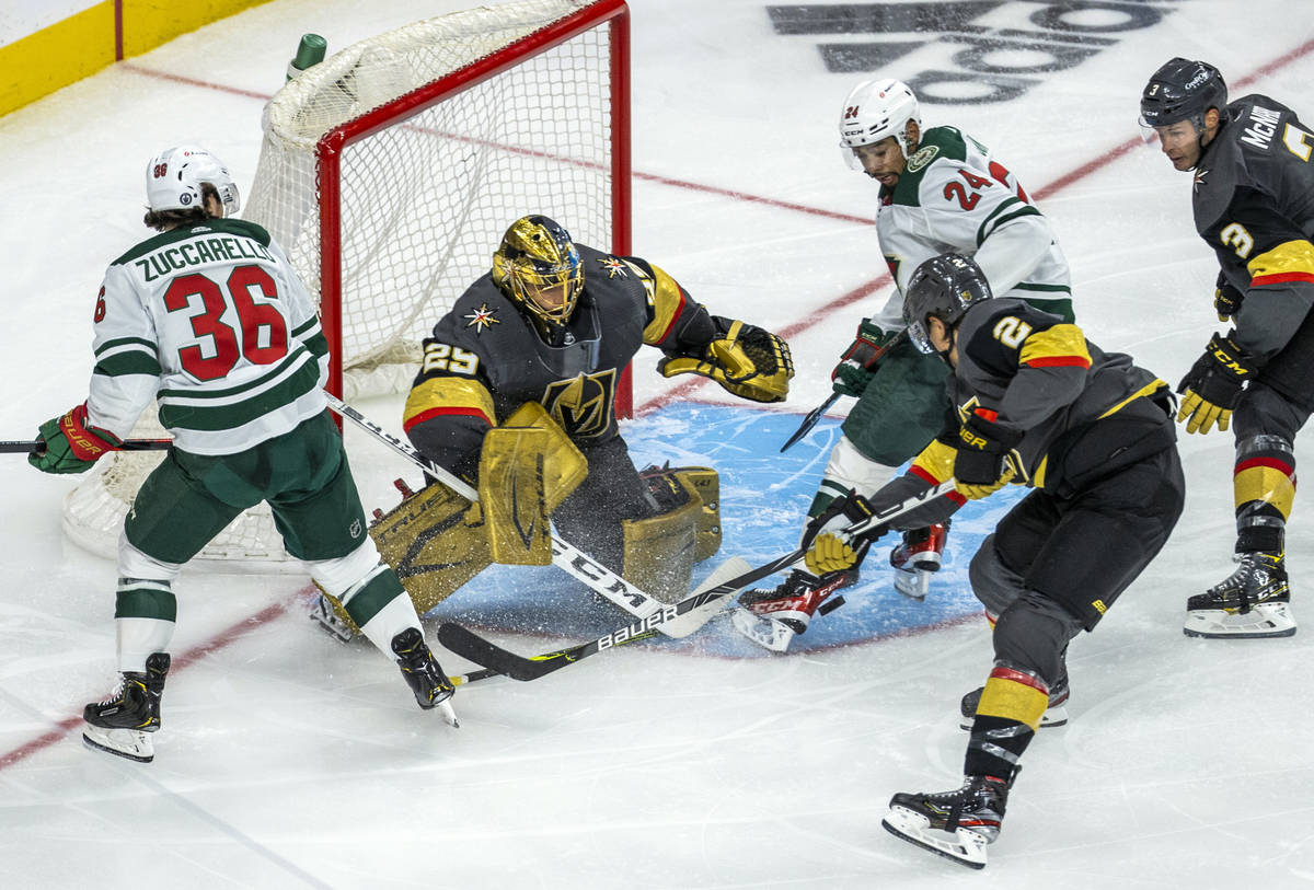 Golden Knights goaltender Marc-Andre Fleury (29) defends the net as Minnesota Wild defenseman M ...