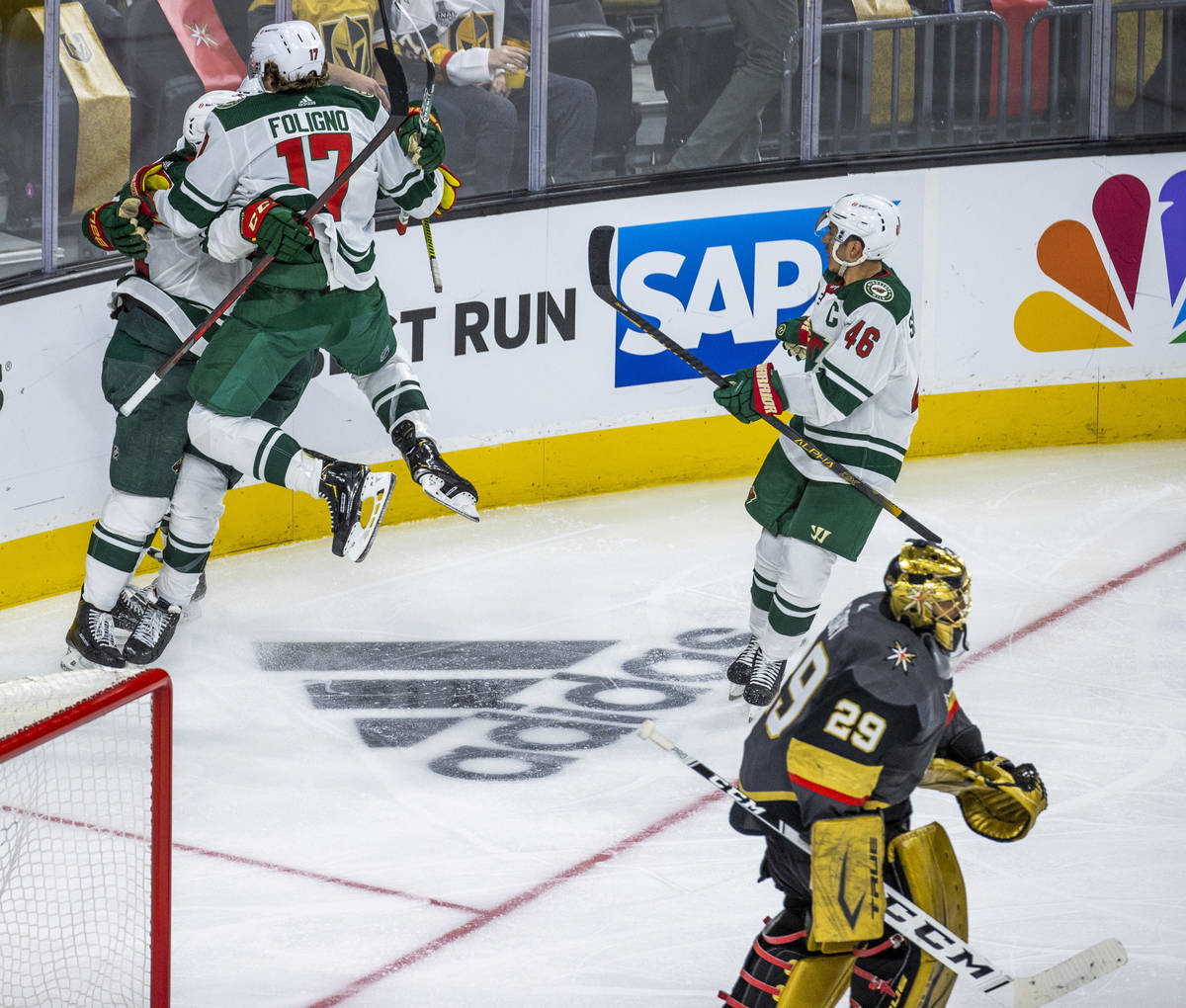 Minnesota Wild players celebrate their winning goal as Golden Knights goaltender Marc-Andre Fle ...