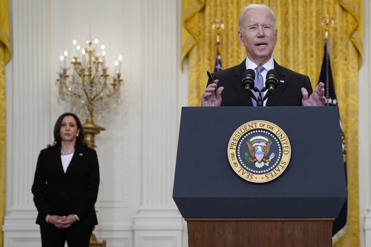 Vice President Kamala Harris listens as President Joe Biden speaks about distribution of COVID- ...