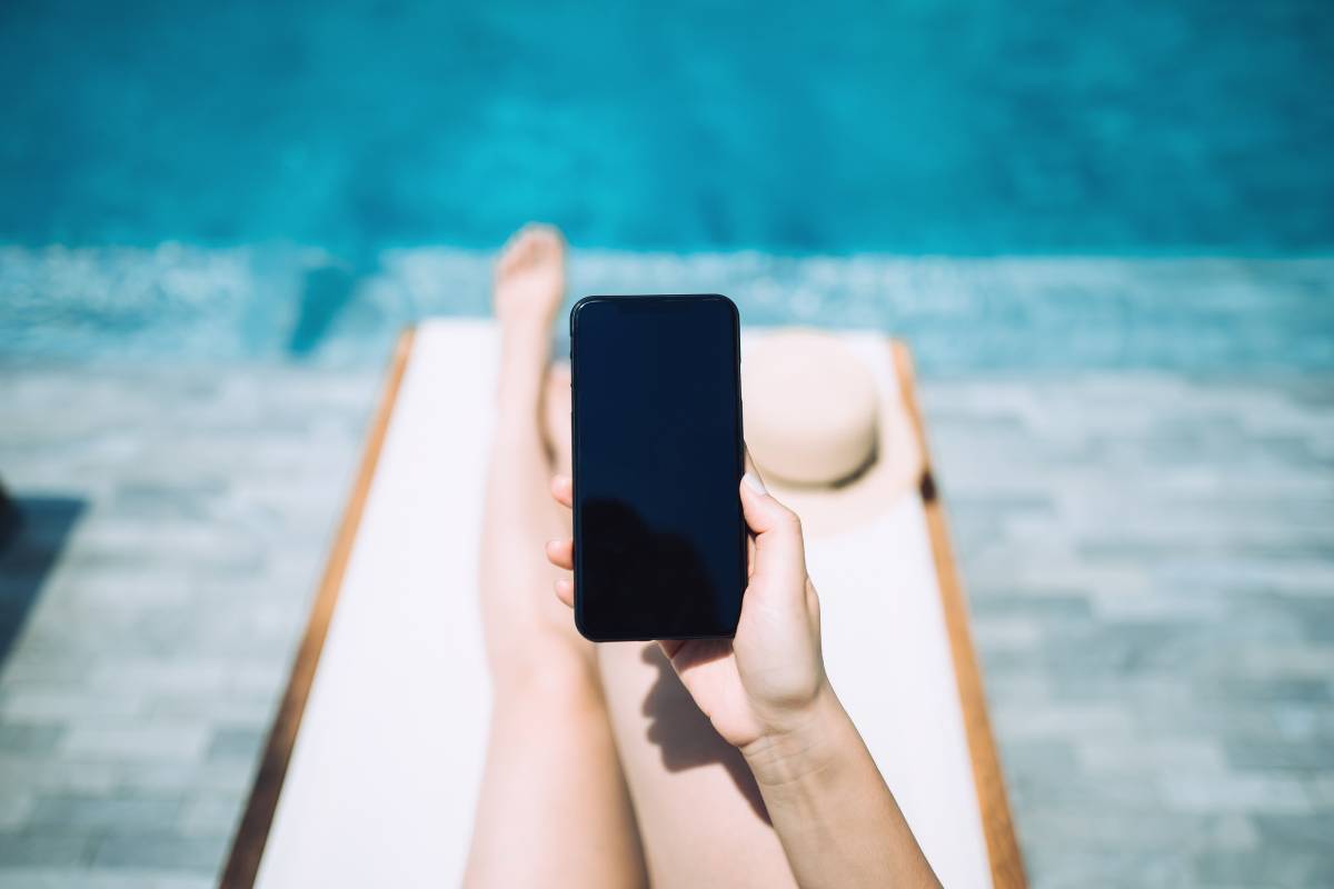 A guest holding a smartphone while poolside. (Courtesy, MGM Resorts International)