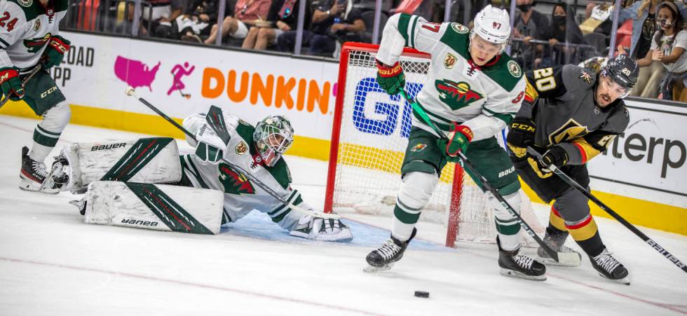 Minnesota Wild goaltender Cam Talbot (33) looks to a deflected puck as teammate Minnesota Wild ...