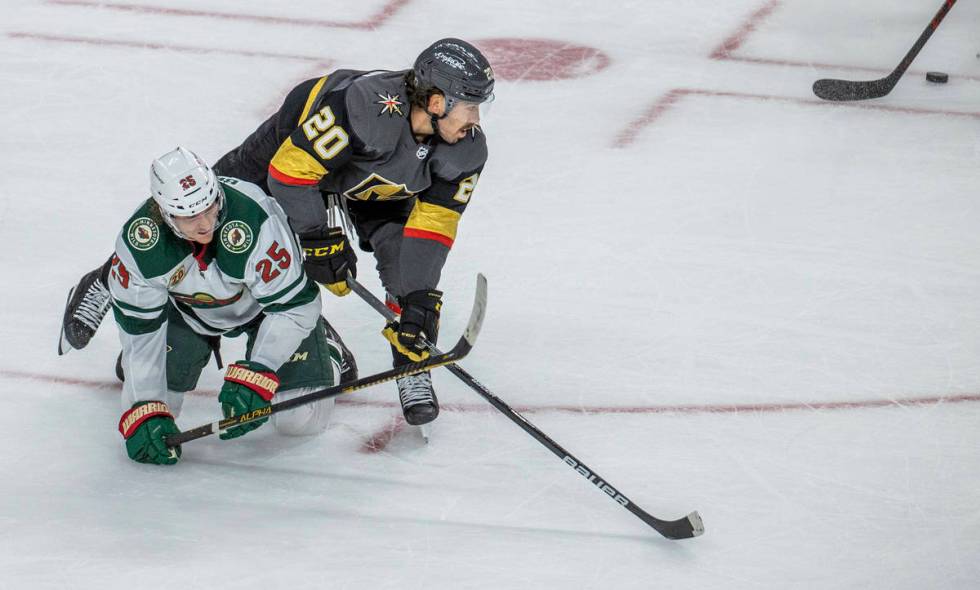 Golden Knights center Chandler Stephenson (20) eyes the puck as he tumbles over Minnesota Wild ...