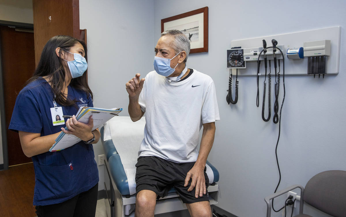 Clinical Research Coordinator Lindsay Kondo, left, checks the current physical status of patien ...