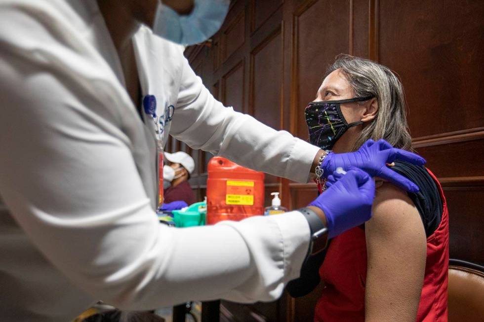 Registered nurse Chika McTier administers the Pfizer shot to Camille Griffin during a pop-up CO ...