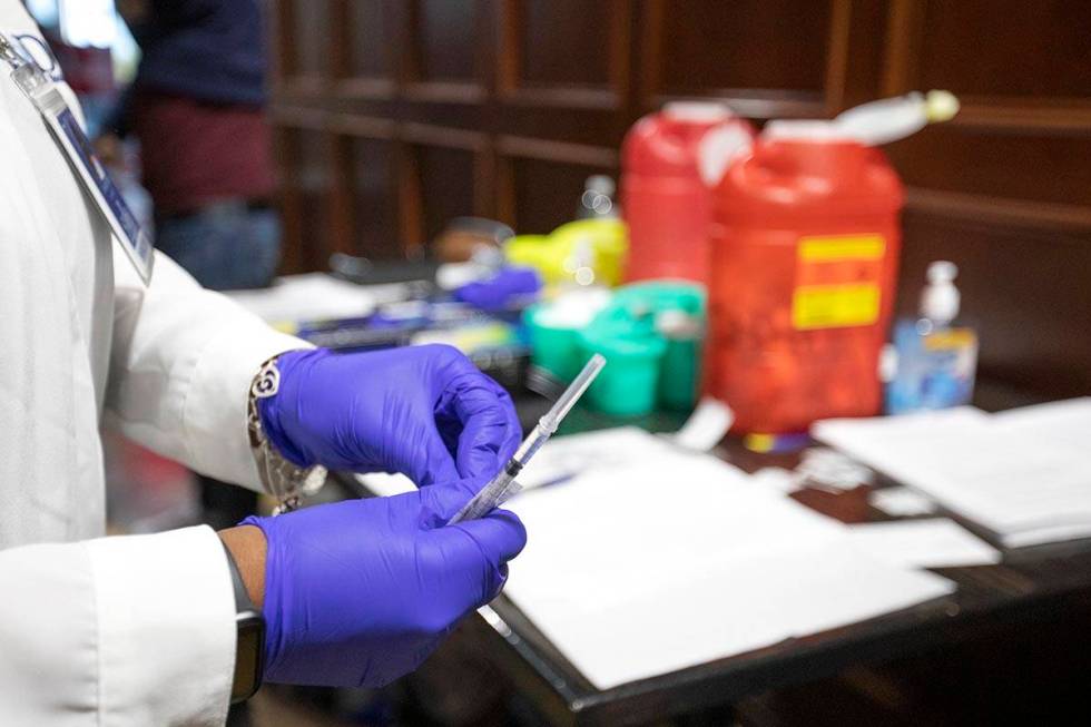 Chika McTier, a registered nurse, prepares a shot during a pop-up COVID-19 vaccine clinic at La ...