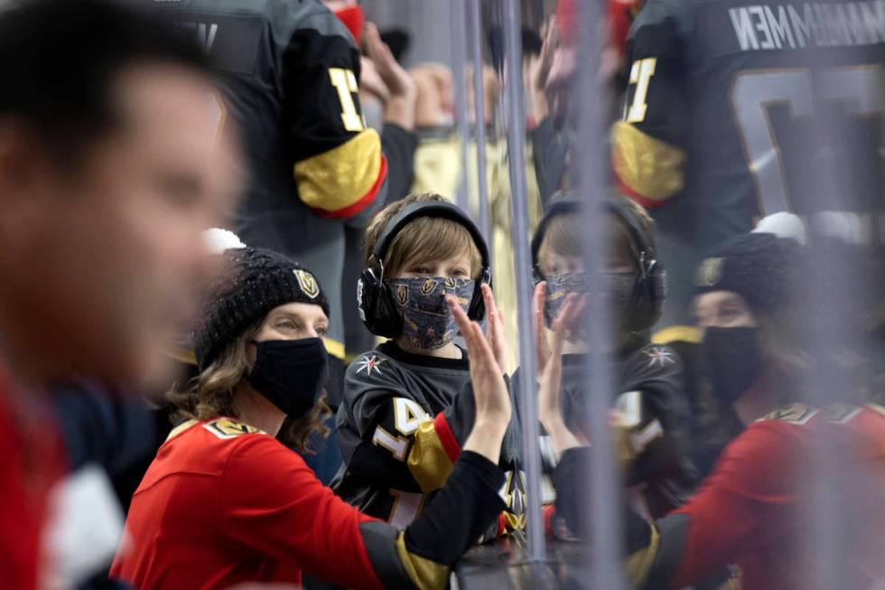 Golden Knights fans clap on the glass before an NHL playoff game between the Golden Knights and ...