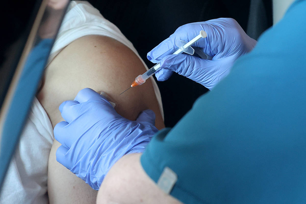 Teresa Woods gives a shot during a drive-thru COVID-19 vaccine clinic in the Bronze Lot at the ...