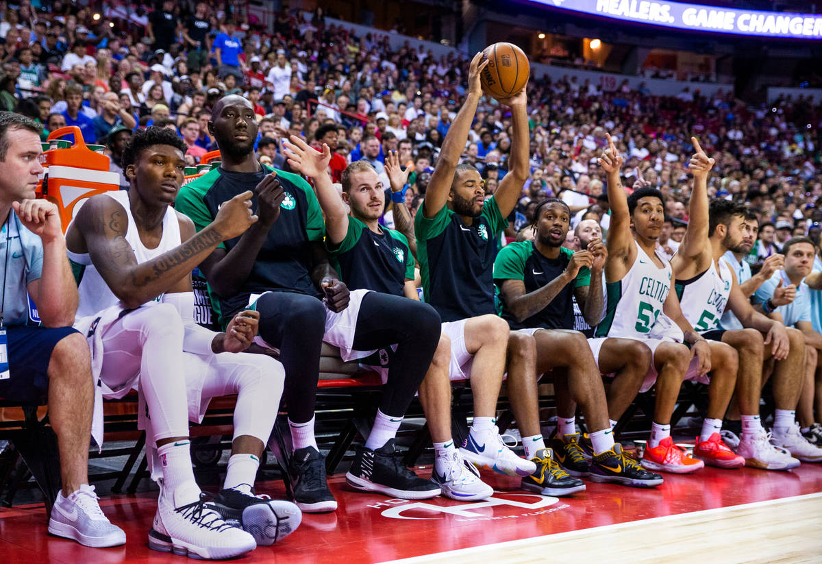 Boston Celtics players including center Tacko Fall, left center, as a loose ball gets to the be ...