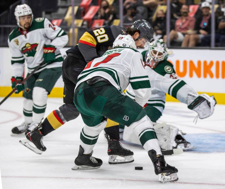 Golden Knights center Chandler Stephenson (20) battles for the puck near the net with Minnesota ...