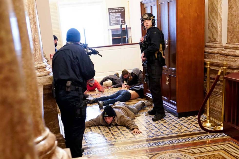 In this Jan. 6, 2021, file photo, U.S. Capitol Police hold rioters at gun-point near the House ...