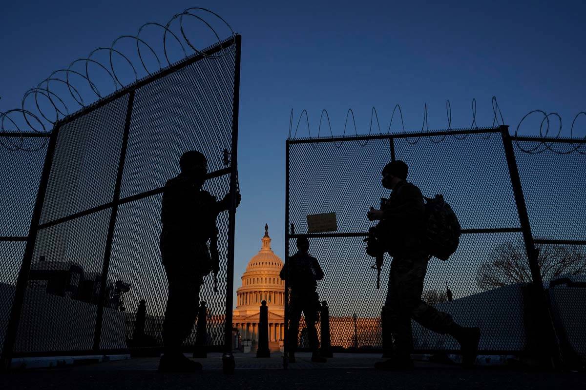 In this March 8, 2021, file photo, members of the National Guard open a gate in the razor wire ...