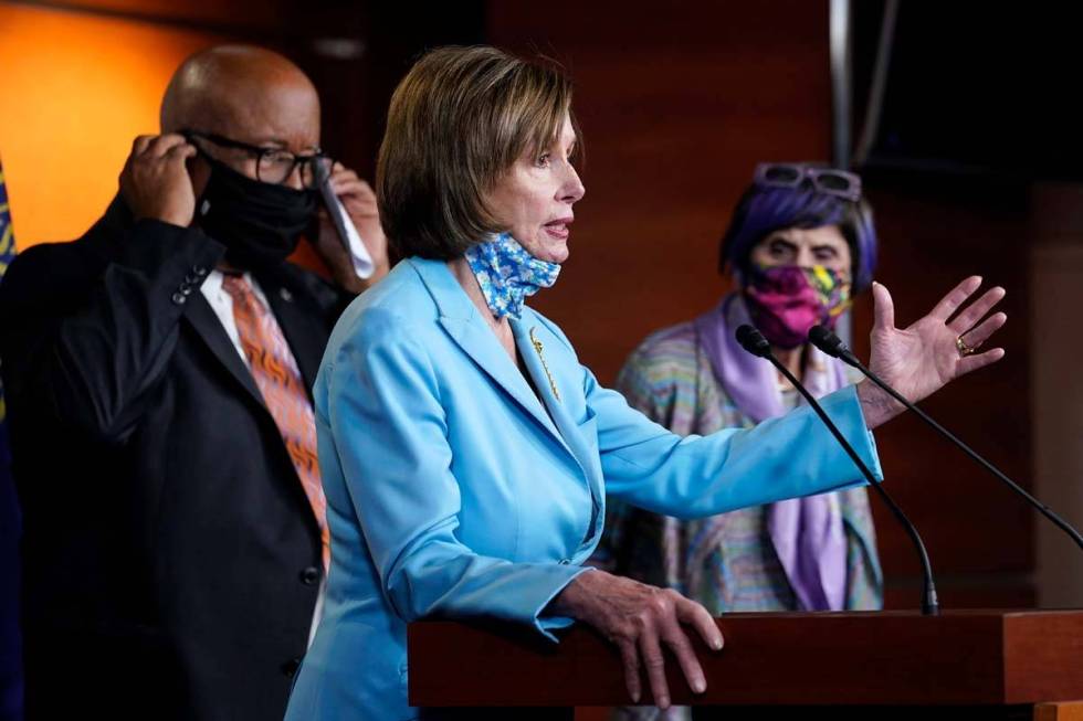 House Speaker Nancy Pelosi of Calif., center, flanked by Rep. Benny Thompson, D-Miss., left, an ...