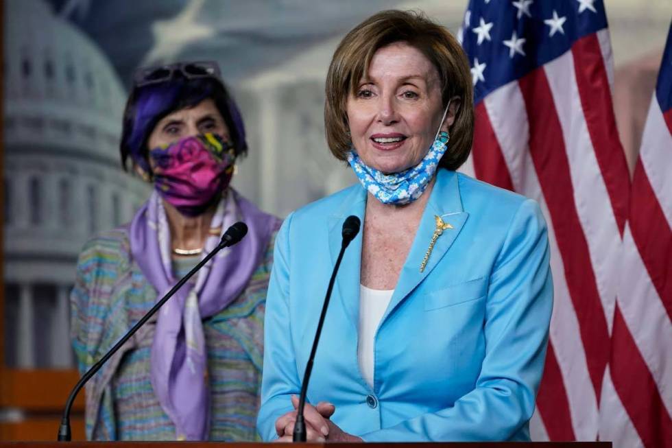 House Speaker Nancy Pelosi of Calif., right, standing with Rep. Rosa DeLauro, D-Conn., left, ta ...