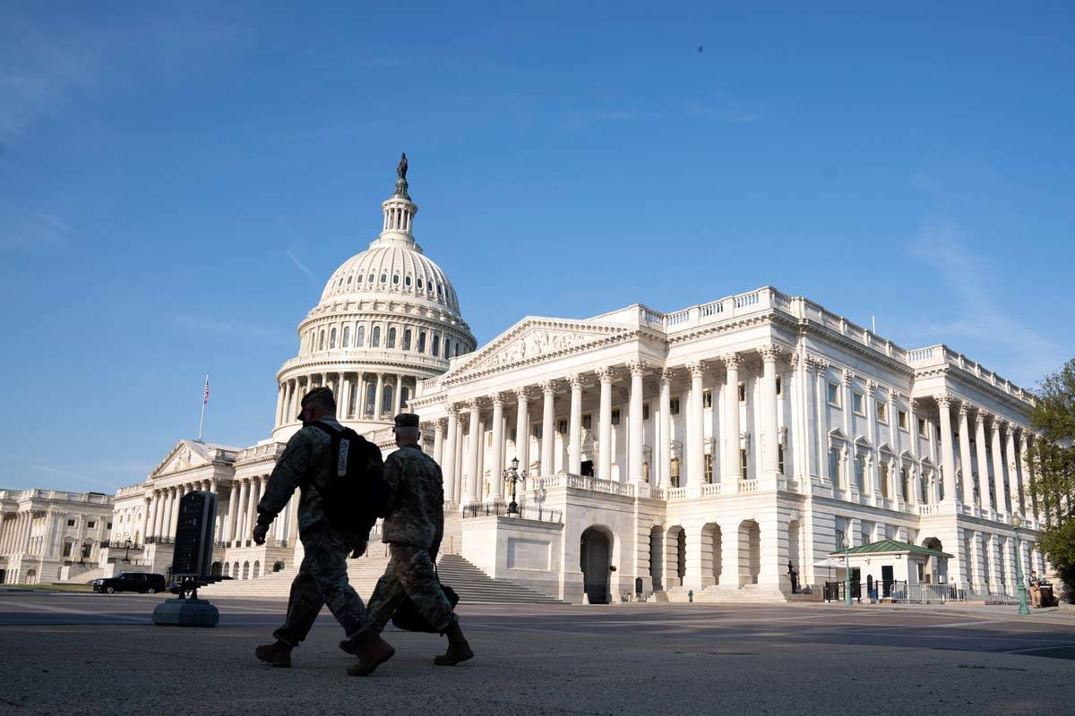 The U.S. Capitol is seen as national guard members pass by on Capitol Hill in Washington, Thurs ...