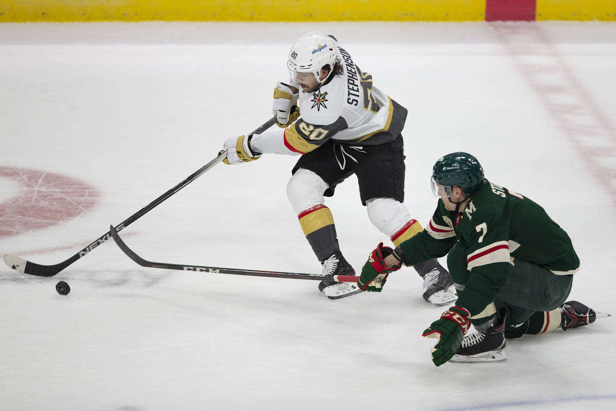 Vegas Golden Knights' Chandler Stephenson (20) handles the puck next to Minnesota Wild's Nico S ...