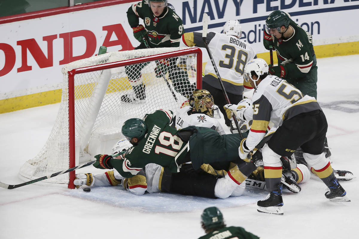 Minnesota Wild's Jordan Greenway (18) falls over Vegas Golden Knights' Alex Pietrangelo (7) whi ...